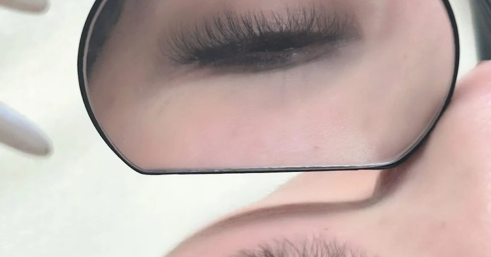 Eyelash extensions seen in a hand mirror at PAYA, near BTS Asok